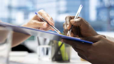 close up man writing signature contract after being hired by recruiter