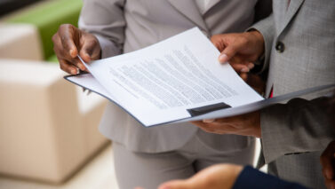 diverse business partners reading contract together