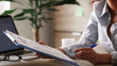 unrecognizable female entrepreneur analyzing business reports while working paperwork office